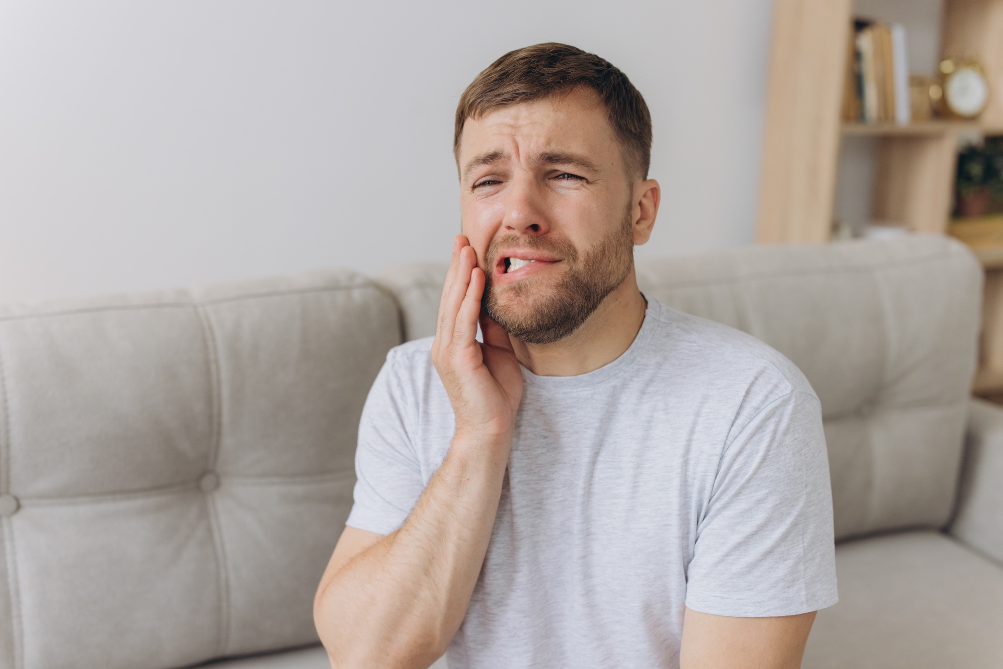 Dental health problems concept. Man suffering from strong toothache.